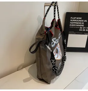Detailed view of the stylish nylon tote bag featuring unique donut embroidery and sturdy ropes.