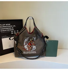 Detailed view of the large capacity canvas tote bag with unique lion embroidery and cross-body strap.