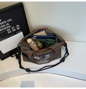Large capacity canvas crossbody shoulder bag with embroidered details and contrast straps.