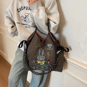 Casual large capacity canvas tote bag with cute cartoon embroidery and thick rope straps.