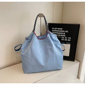 Casual light blue nylon tote bag with patterned straps and stylish red contrast piping design.