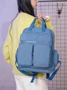 Zaino in nylon a tinta unita elegante con tasche frontali multiple e manico, vista principale.