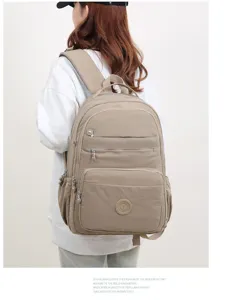 Vista dettagliata dello zaino casual in nylon kaki indossato da una modella con tasche.