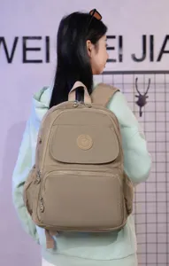 Casual nylon travel backpack with multi-compartments and round logo patch design.