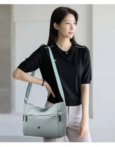 Detailed view of the casual mint green oxford cloth crossbody bag with multiple front zip pockets.