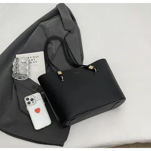 Detailed view of a stylish black PU leather tote bag, showing premium texture and sturdy straps.