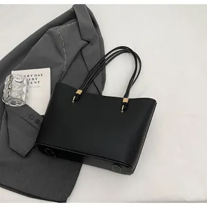 Detailed view of a minimalist black PU leather tote bag with thin double straps and metal rings.