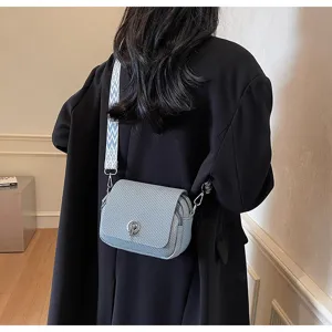 Detail view of the stylish woven texture mini crossbody bag with wide strap and metal lock.