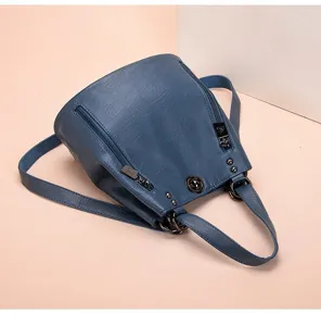 Primo piano dello zaino blu in pelle morbida con cerniera lampo e dettagli metallici.