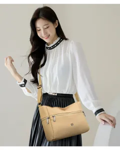 Detailed view of casual women canvas crossbody bag in beige, featuring adjustable strap and zip.