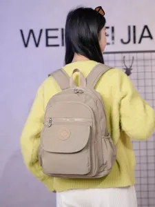 Lightweight solid color casual backpack for women, large capacity travel and school bag.