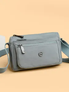 Solid color nylon crossbody bag for women, versatile multi-pocket casual shoulder bag.