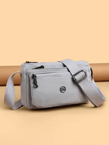 Light grey nylon crossbody bag for women, versatile everyday shoulder bag with multiple pockets.