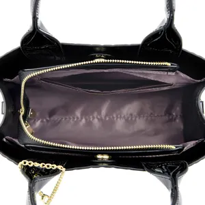 Black patent leather tote handbag with crocodile texture and multi-compartment interior.