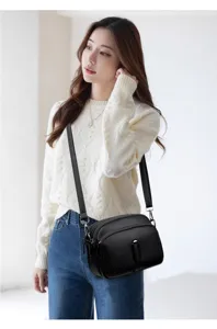 Model wearing black soft leather shoulder bag detail, stylish crossbody bag for daily look.