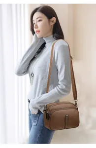 Detailed shot of women soft leather crossbody phone bag in brown, elegant everyday shoulder bag.