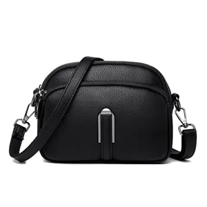 Women's black soft leather crossbody phone bag with multi zippers and metallic front clasp.