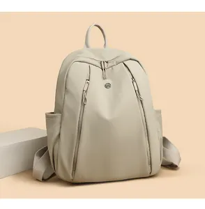 Detailed view of fashionable beige women backpack with multi pockets and zip closure.