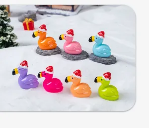 Close-up of mini resin flamingo figurines wearing cute Santa hats, colorful craft accessories.