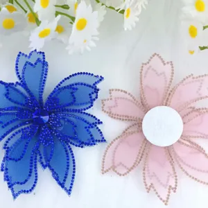 Close-up detail of rhinestone mesh flower accessories, vibrant blue and soft pink patches.