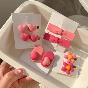 Rosa Haarklammern Set mit niedlichen Herz und Schleife Designs, detaillierte Nahaufnahme Alltag.