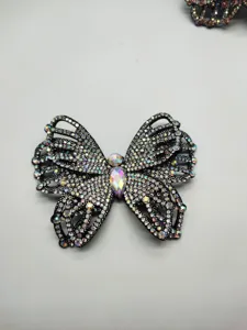 Close-up detail of sparkling rhinestone butterfly patch, sparkling crystal clothing accessory.