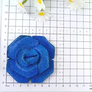 Vue détaillée en gros plan de l'accessoire floral de rose en strass bleu étincelant.