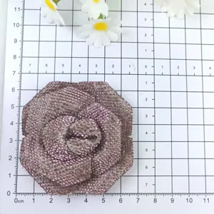 Vue détaillée du charm de chaussure et de la broche fleur de rose en strass étincelants.