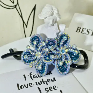 Exquisite blue rhinestone hair claw clip detail, sparkling floral design hair accessory for women.