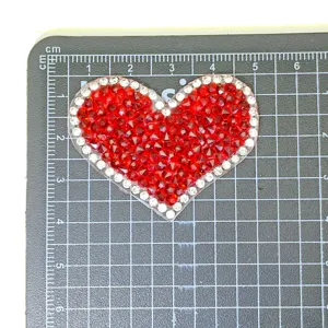 Nahaufnahme rot-weißes Strass Herz Aufnäher Zubehör für DIY Bastelkleidung Details.