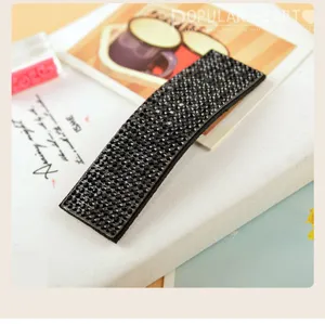 Close-up detail of a sparkling black rhinestone hair clip, elegant crystal barrette design.