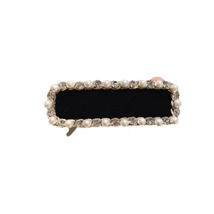 Elegant black velvet hair barrette with sparkling rhinestones and faux pearls for women.
