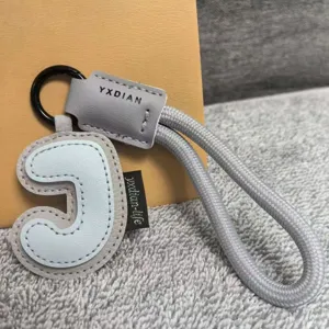 Leather letter keychain with braided strap, stylish dopamine bag pendant for daily use.