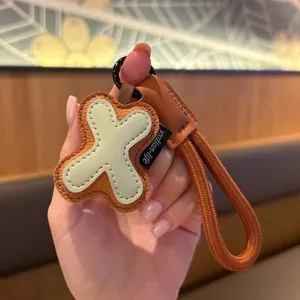 Stylish leather cross keychain and bag charm, unique Japanese Korean style accessory gift.