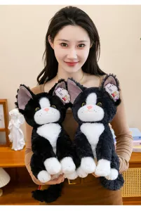 Primo piano dettagliato di simpatici gatti di peluche Devon Rex nero e bianco tenuti in mano.
