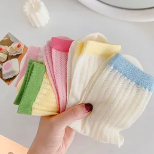 Nahaufnahme von bunten Bonbon-Socken im Fächer mit gerippten Bündchen, weiche Strickstruktur.