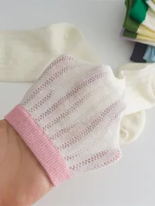 Nahaufnahme von atmungsaktiven Mesh-Strümpfen mit feiner Textur und rosa geripptem Bündchen.