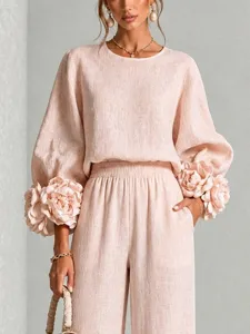 Vista dettagliata dell'elegante completo rosa a due pezzi con polsini floreali.