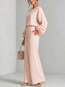 Dettaglio dell'elegante completo rosa chic arricchito da splendidi polsini floreali.