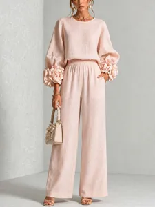 Completo elegante in due pezzi con top a maniche lunghe e pantaloni larghi floreali.