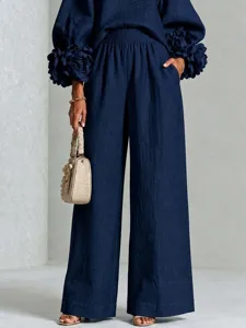 Completo due pezzi blu scuro in lino con maniche lunghe con polsini floreali e pantaloni.