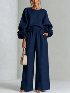 Completo blu scuro in due pezzi con top a maniche lunghe con fiori e pantaloni ampi.