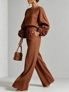Set marrone di due pezzi con top a maniche lunghe con polsini floreali e pantaloni larghi.