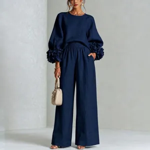 Completo blu scuro con polsini floreali 3D e pantaloni larghi eleganti da donna.