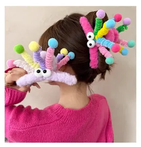 Cute colorful plush hair claw with funny googly eyes and pom-poms for playful dopamine hairstyles.