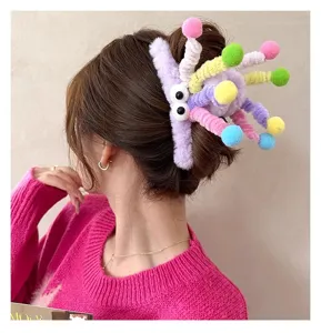 Plush hair claw clip with colorful pom poms and cute googly eyes, fun dopamine hair accessory.