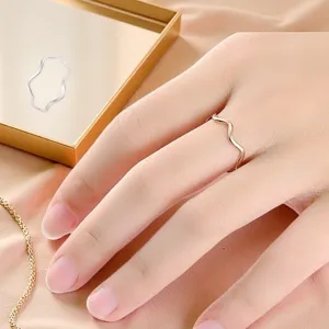 Primo piano dettagliato dell'anello ondulato minimalista in acciaio inox indossato.