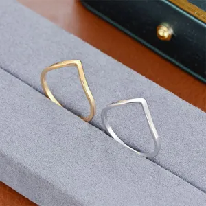 Primo piano dettagliato di anelli minimalisti a V in oro e argento, elegante espositore.