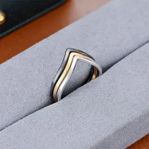 Primo piano dettagliato di un anello in acciaio inossidabile a V multicolore in velluto.