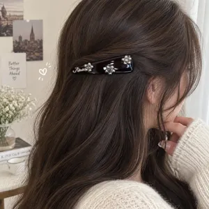Close-up detail of the elegant rhinestone triangle hair clip, side wearing style for women.